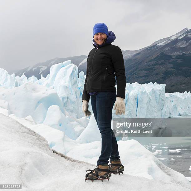 a woman with crampon spikes on her hiking boots on moreno glacier, los glaciares national park; santa cruz province, argentina - moreno gletscher stock-fotos und bilder