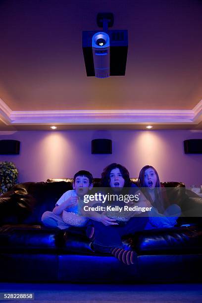 siblings watching movie - living projector stockfoto's en -beelden