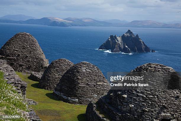 stone 'beehive' monk huts (clochans) with a view of skellig beag - skellig michael 個照片及圖片檔