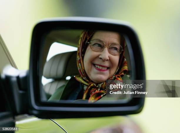 Queen Elizabeth II is seen reflected in the wing mirror of her Land Rover as she follows The Duke of Edinburgh as he competes in the Driving Grand...