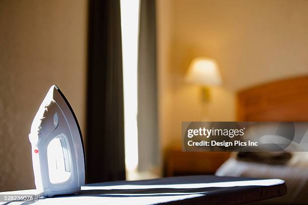 iron and ironing board in hotel room - bügelbrett stock-fotos und bilder