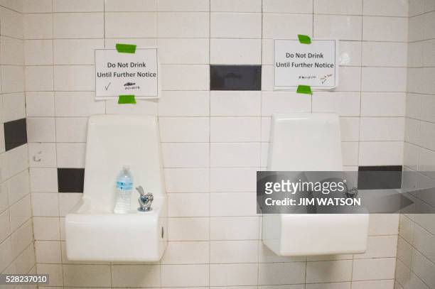Placards posted above water fountains warn against drinking the water at Flint Northwestern High School in Flint, Michigan, May 4 where US President...