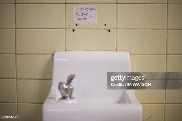 Placard posted above a water fountain warns against drinking the water at Flint Northwestern High School in Flint, Michigan, May 4 where US President...