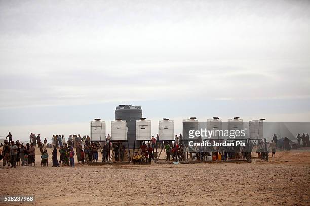 Syrian refugees arrive at the Jordanian military crossing point of Hadalat at the border with Syria after a long walk through the Syrian desert on...