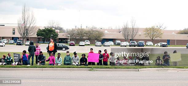 Children line up to greet President Obama's motorcade before he speaks at Northwest High School about the Flint water contamination crises May 4,...