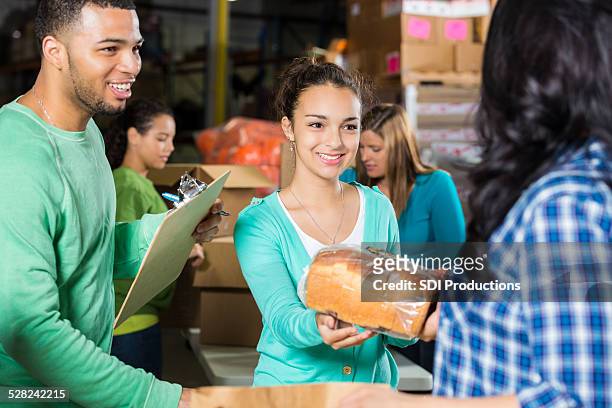 teenager volunteering to accept donation at community food bank - grateful words stock pictures, royalty-free photos & images