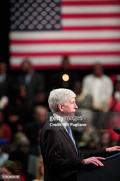 Michigan Governor Rick Snyder stands and listens the boos of the crowd when he takes to the stage to speak before U.S. President Barack Obama speaks...