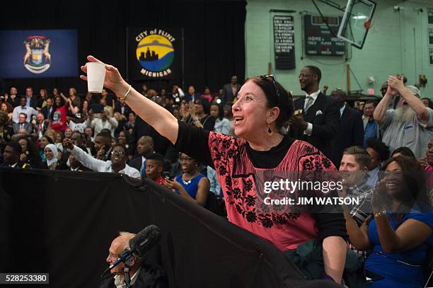 Sue Quintanilla offers US President Barack Obama a glass of water as he speaks at Flint Northwestern High School in Flint, Michigan, May 4, 2016...
