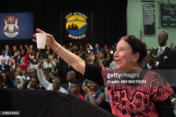 Sue Quintanilla offers US President Barack Obama a glass of water as he speaks at Flint Northwestern High School in Flint, Michigan, May 4, 2016...