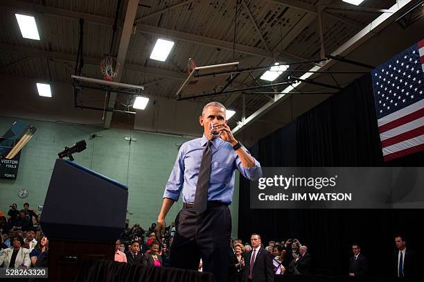 President Barack Obama drinks a glass of water as he speaks at Flint Northwestern High School in Flint, Michigan, May 4, 2016 after meeting with...