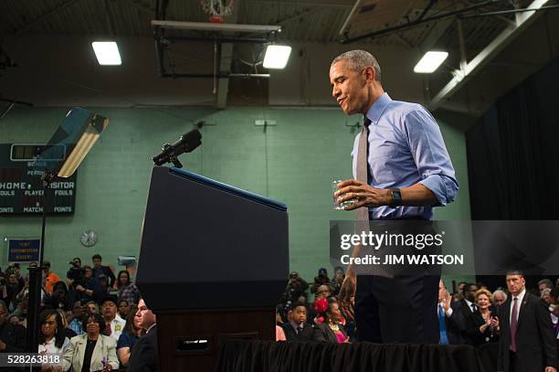 President Barack Obama drinks a glass of water as he speaks at Flint Northwestern High School in Flint, Michigan, May 4, 2016 after meeting with...
