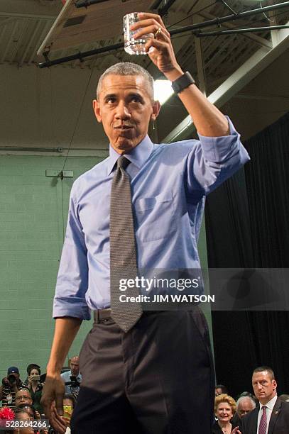 President Barack Obama drinks a glass of water as he speaks at Flint Northwestern High School in Flint, Michigan, May 4, 2016 after meeting with...