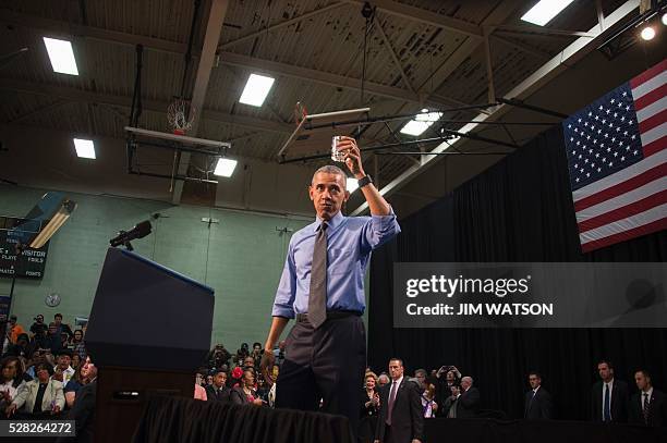 President Barack Obama drinks a glass of water as he speaks at Flint Northwestern High School in Flint, Michigan, May 4, 2016 after meeting with...