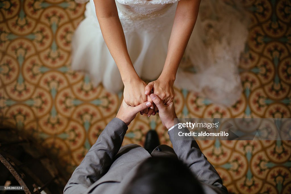 Close up shots of bride and groom holding hands