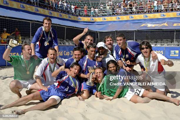 France's beach soccer players pose with the trophy after beating Portugal in the final of the Fifa Beach Soccer World Cup, held in Rio de Janiero's...