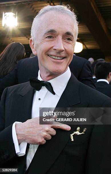 Actor Anthony Daniels aka C-3PO shows a pin of his character as he arrives for the screening of US director George Lucas' film "Star Wars : Episode...