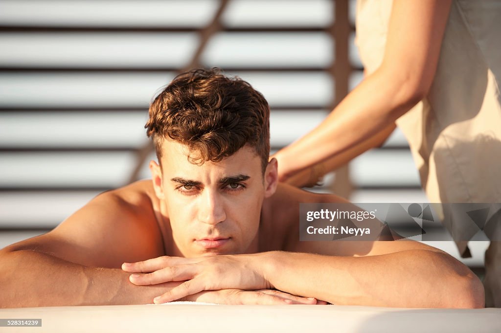 Young Man Getting Massage on the Outdoors Spa Resort