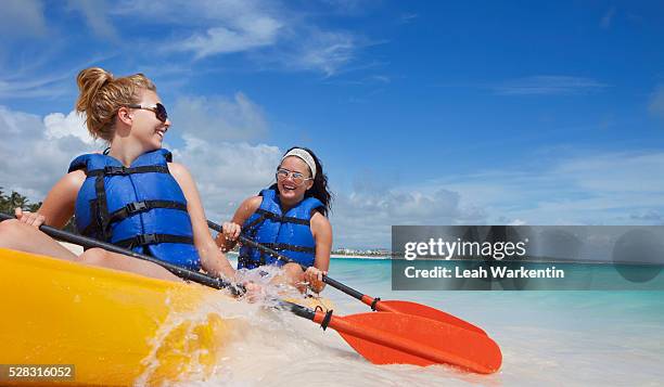 two women in lifejackets paddling in a yellow boat; punta cana la altagracia dominican republic - punta cana foto e immagini stock