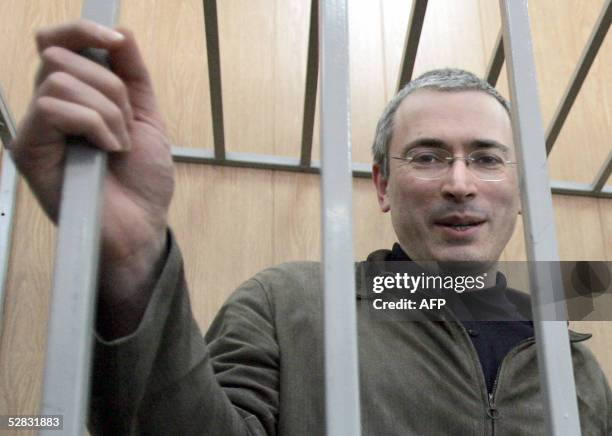 Imprisoned former head of the Yukos oil company, Mikhail Khodorkovsky stands in the defendant's box during his trial in Moscow, 16 May 2005. Mikhail...