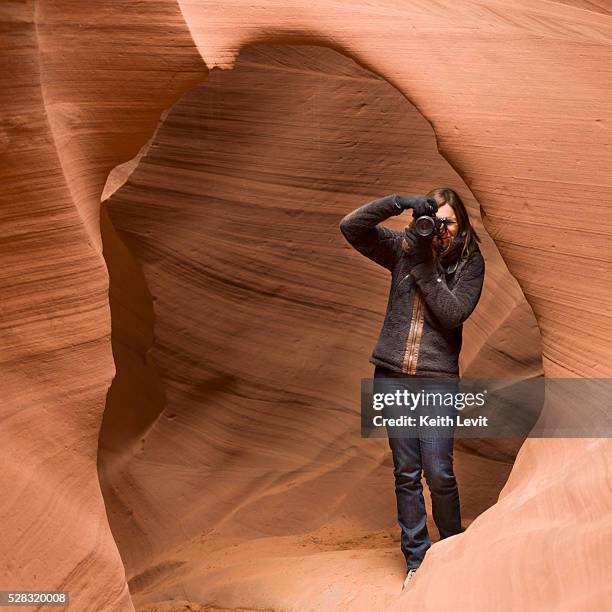 a woman takes a photograph in antelope canyon; arizona united states of america - naturwunder stock-fotos und bilder