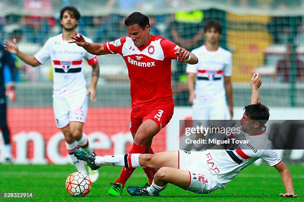 Aaron Galindo of Toluca tries to avoid the slide by Jonathan Calleri of Sao Paulo during the match between Toluca and Sao Paulo as part of the Copa...