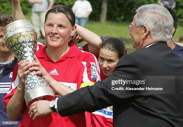 Pia Wunderlich of FFC Frankfurt is presented with the German Womens Football League trophy by the President of the German Football League, Theo...