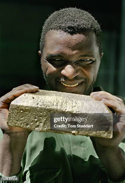 Miner Estavao Macuacua holds a newly produced bar of gold at the Driefontein Gold Mine near Carltonville, South Africa. The mine is owned by Gold...