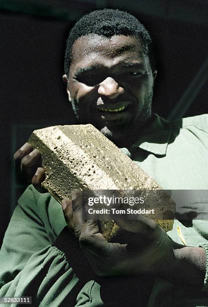 Miner Estavao Macuacua holds a newly produced bar of gold at the Driefontein Gold Mine near Carltonville, South Africa. The mine is owned by Gold...