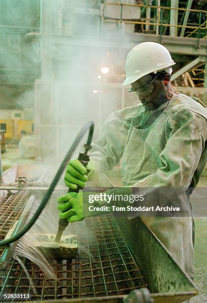 Miner cleans a newly poured gold bar at Driefontein Gold Mine near Carltonville, South Africa. The mine is owned by Gold Fields Ltd. Who produce 4.3...