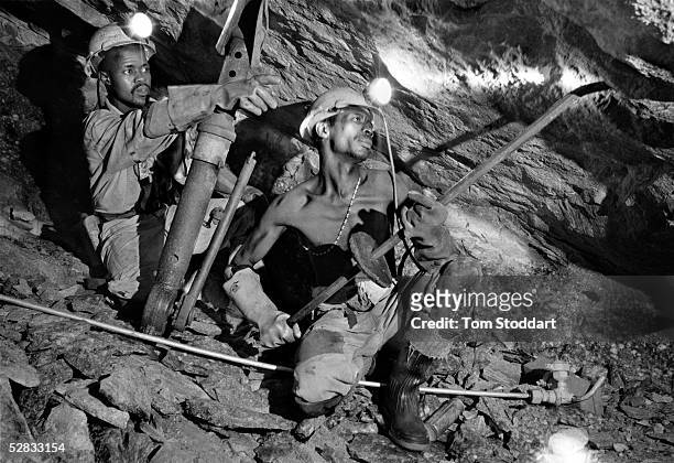 Two miners excavating gold at the Kloof Gold Mine near Carltonville, South Africa.Miners work thousands of metres underground in extreme temperatures...