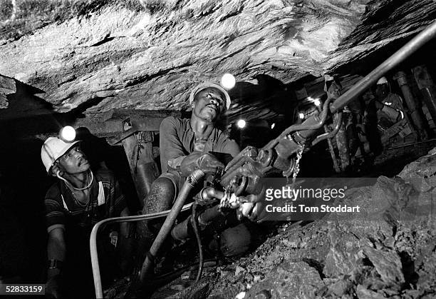 Two miners excavating gold at the Kloof Gold Mine near Carltonville, South Africa. Miners work thousands of metres underground in extreme...