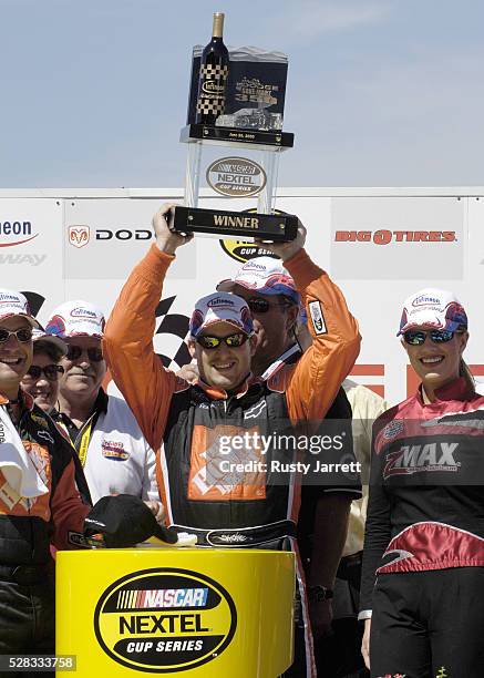 Tony Stewart, driver of the Home Depot Chevrolet, holds up the trophy after winning the NASCAR Nextel Cup Series Dodge/Save Mart 350 on June 26, 2005...