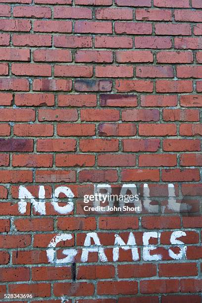 a brick wall with the message written saying no ball games; craster, northumberland, england - craster stock pictures, royalty-free photos & images