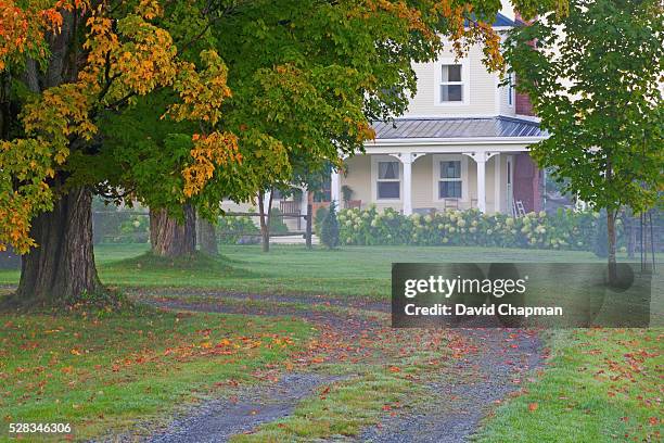 house in the fog in autumn; ville de lac brome, quebec, canada - automne ville stockfoto's en -beelden