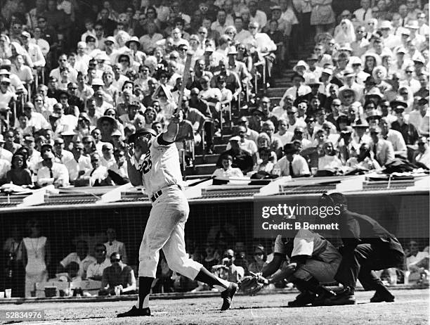 American professional baseball player Frank Howard of the Los Angeles Dodgers hits a homerun as spectators look on during the fourth game and final...