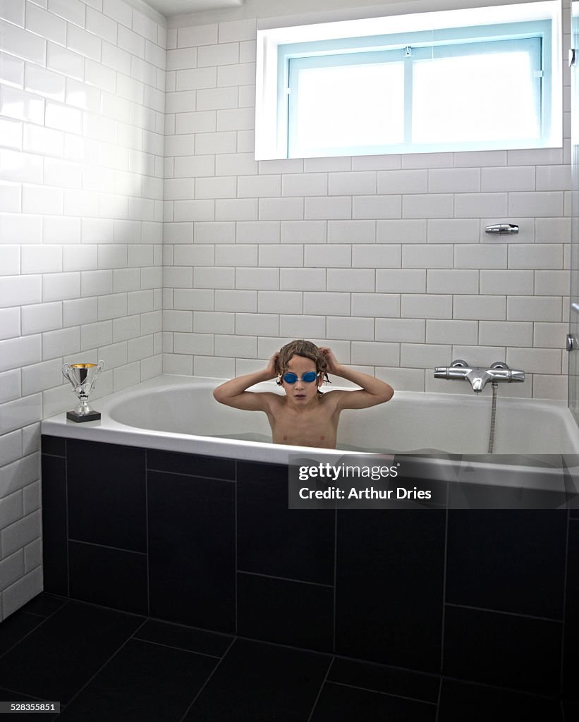 Boy preparing for swimming contest in bathroom