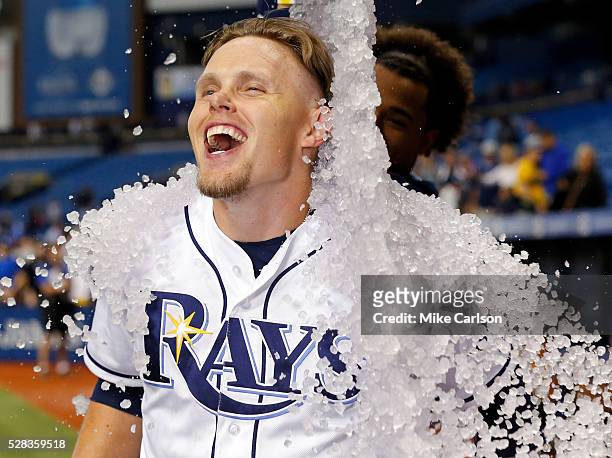 Brandon Guyer of the Tampa Bay Rays reacts as he gets a bucket of ice poured on him to celebrate a win over the Los Angeles Dodgers in a game at...