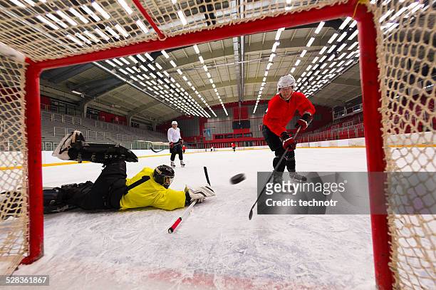 giocatori di hockey su ghiaccio punteggio dell'obiettivo - difensore hockey su ghiaccio foto e immagini stock