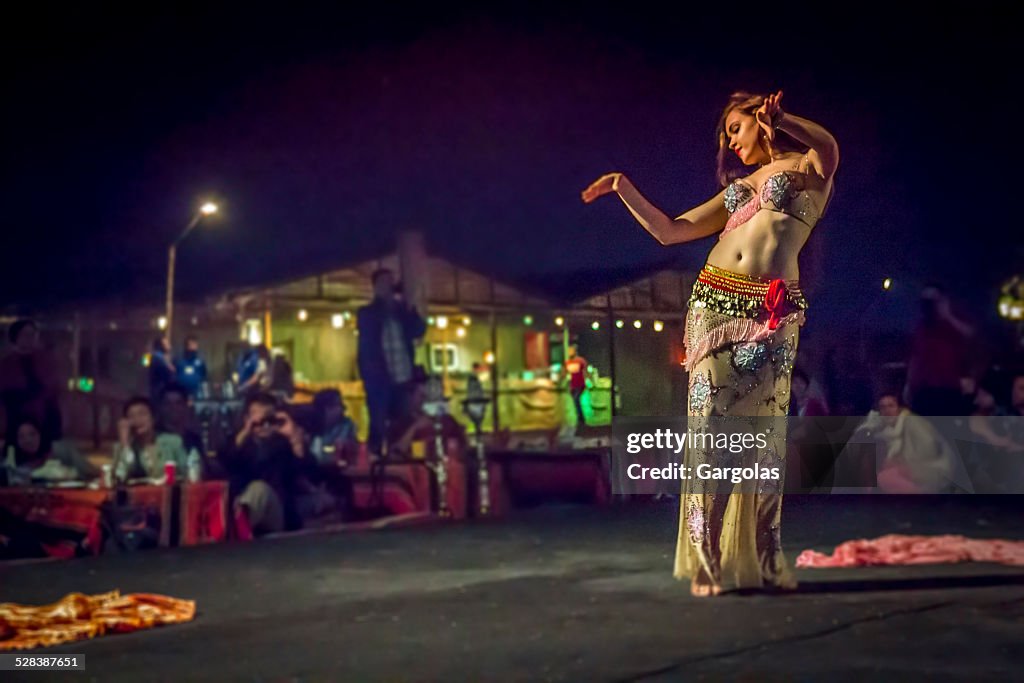 Dançarina da Dança do Ventre em ação com Fantasia de multicolored
