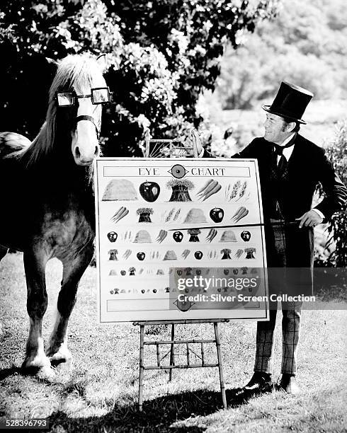Doctor John Dolittle, played by English actor Rex Harrison , conducts an eye test on a bespectacled horse, in 'Doctor Dolittle', directed by Richard...