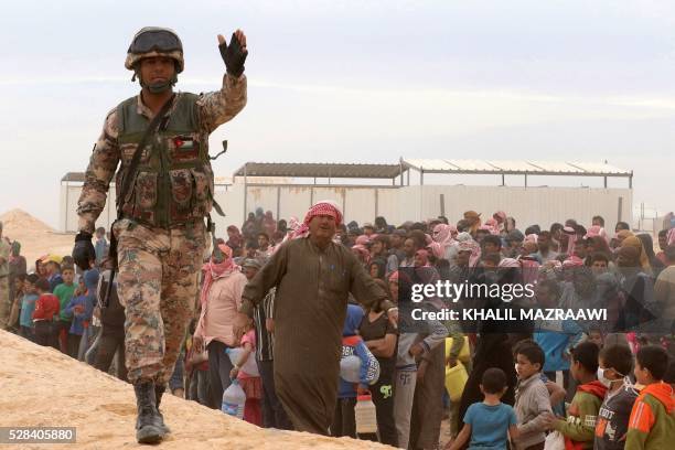 Jordanian soldier stands guard as Syrian refugees arrive to a camp on the Jordanian side at the north east of Jordan's border with Syria, at the...