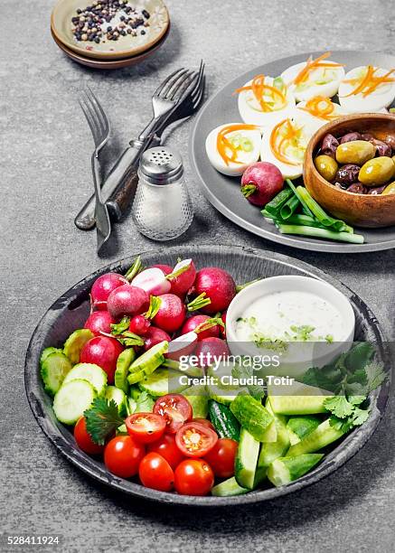 plates of fresh vegetables and deviled eggs - deviled egg stock pictures, royalty-free photos & images