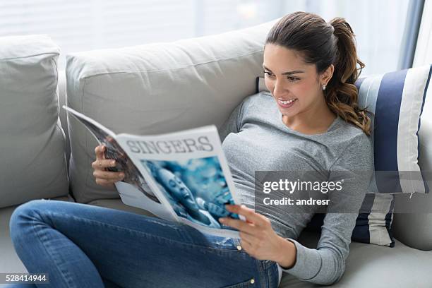 mujer relajándose en casa leyendo - mujer revista fotografías e imágenes de stock