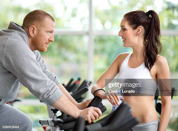 woman flirting with man in gym - spin instructor stock pictures, royalty-free photos & images