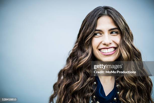 portrait of young woman on plain background - wavy hair imagens e fotografias de stock