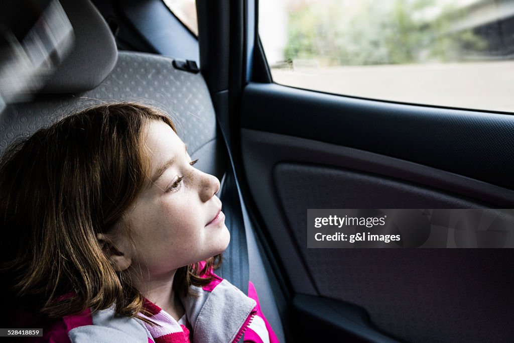 Girl (7yrs) looking out car window