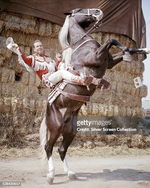 American singer and cowboy actor Roy Rogers on his rearing palomino horse, Trigger, circa 1950.