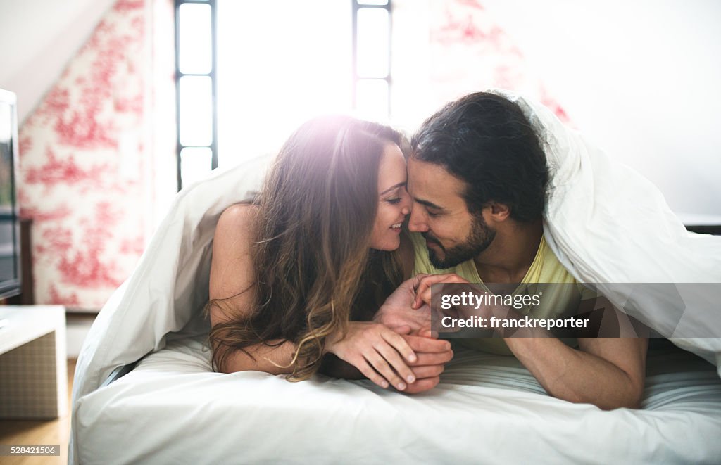 Couple kissing on the bed on early morning