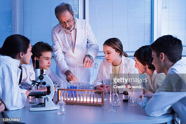 senior teacher teaching chemistry to group of high school students. - children in a lab stock pictures, royalty-free photos & images