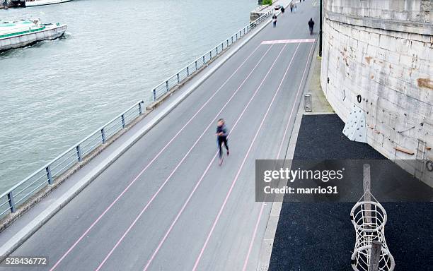silhouette läufer in der nähe der seine und lastkahn - running paris stock-fotos und bilder